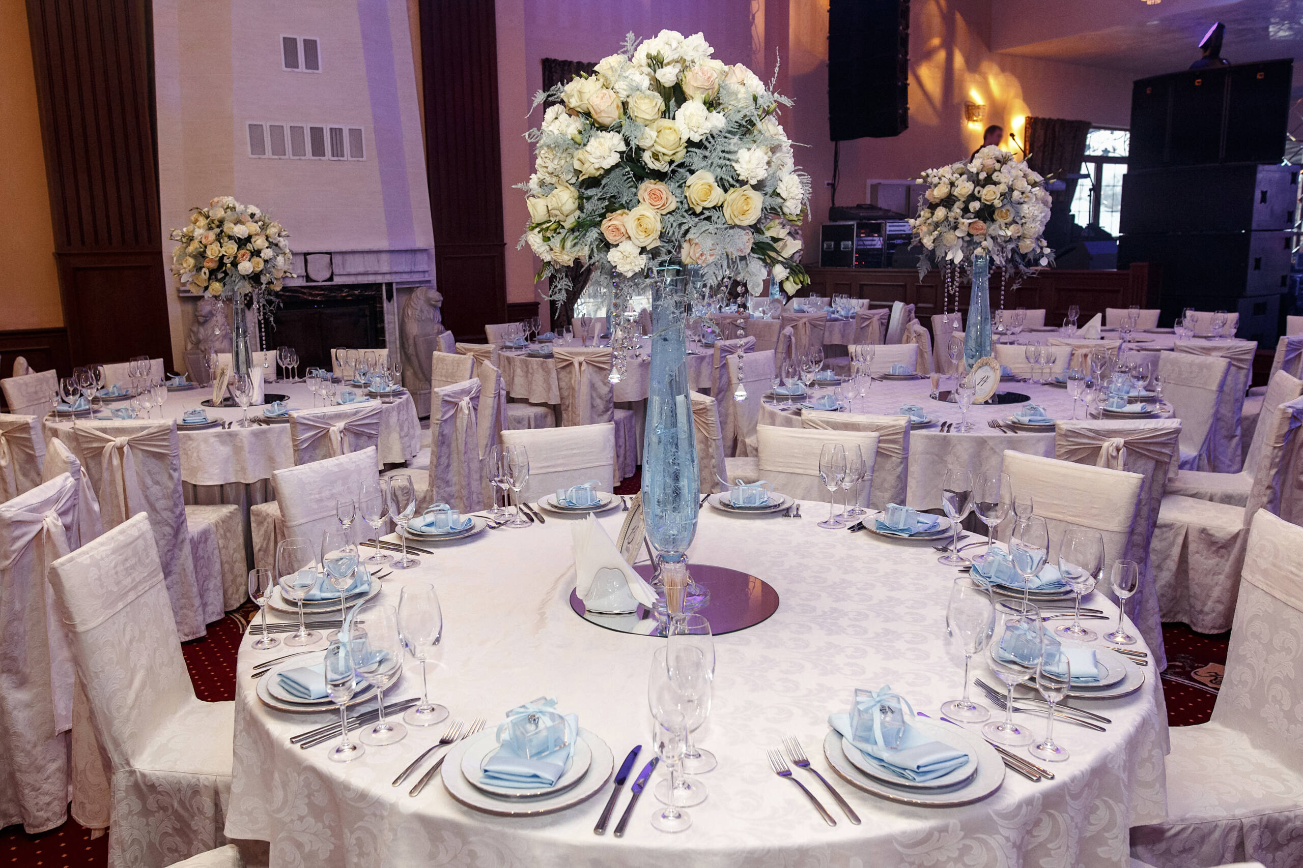 luxury wedding decor with flowers and glass vases with jewels on round tables. arrangements of decorations at wedding reception. expensive catering. space for text