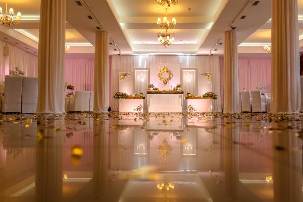 Festive table decorated with composition of white, red and pink flowers and greenery in the banquet hall. Table newlyweds in the banquet area on wedding party