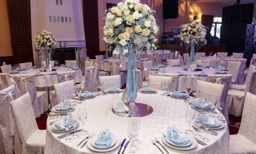 luxury wedding decor with flowers and glass vases with jewels on round tables. arrangements of decorations at wedding reception. expensive catering. space for text
